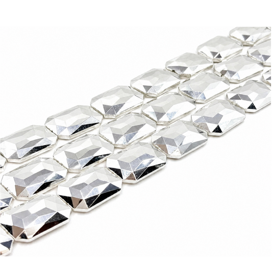  "Close-up of three strands of large shiny silver faceted rectangle crystal glass beads on white background"