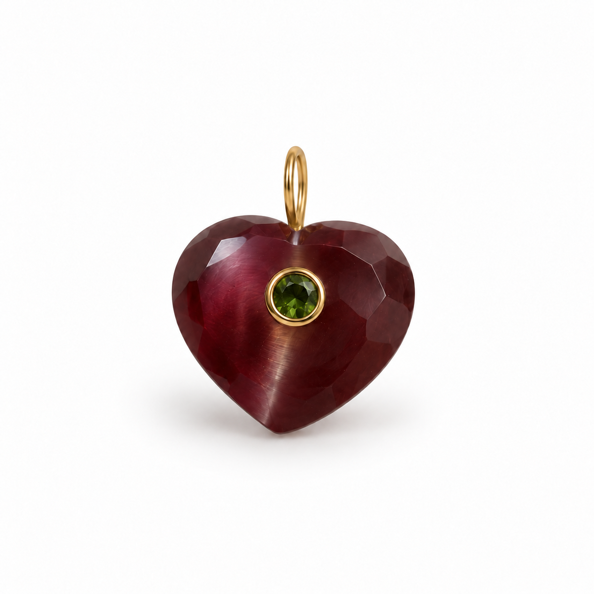 A faceted heart-shaped ruby pendant with a small round green peridot gemstone and gold bezel, suspended from a gold bail, shown on a plain white background.