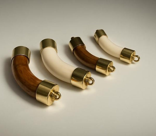 Three decorative handles with wooden and gold finishes on a neutral background