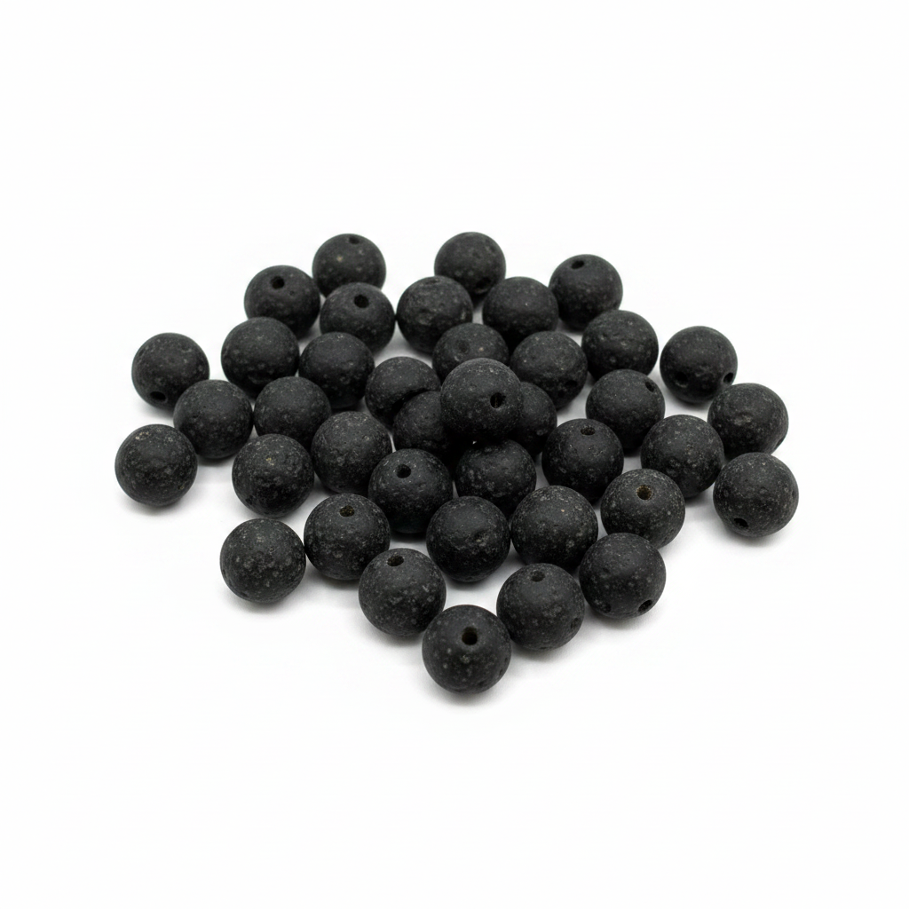 Black recycled African glass round sphere beads 12mm matte texture handmade in Ghana, scattered on white background