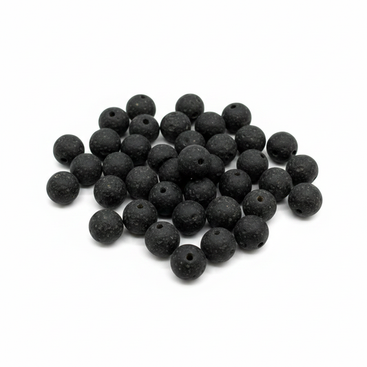 Black recycled African glass round sphere beads 12mm matte texture handmade in Ghana, scattered on white background