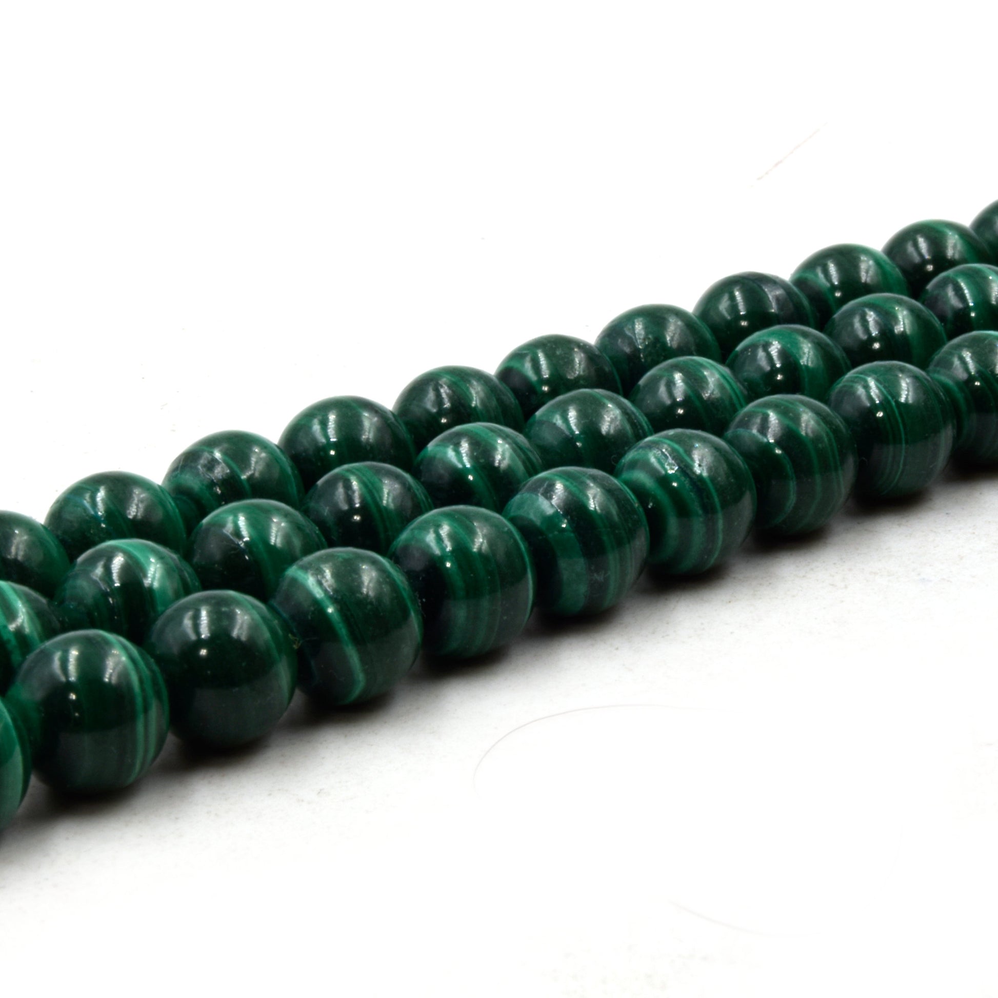 A necklace of green 8mm round malachite beads on a white background