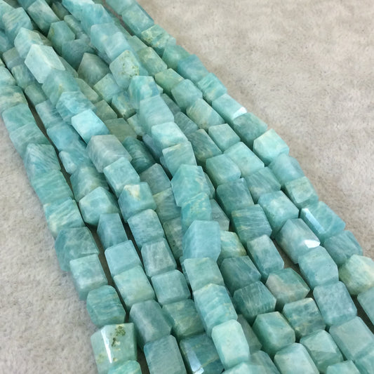 Image of a strand of 10mm Amazonite Freeform Rectangle Beads. The beads have a rectangle shape and a natural blue-green color with varying patterns and textures. Each bead is approximately 10mm in size and can be used for jewelry or craft projects.