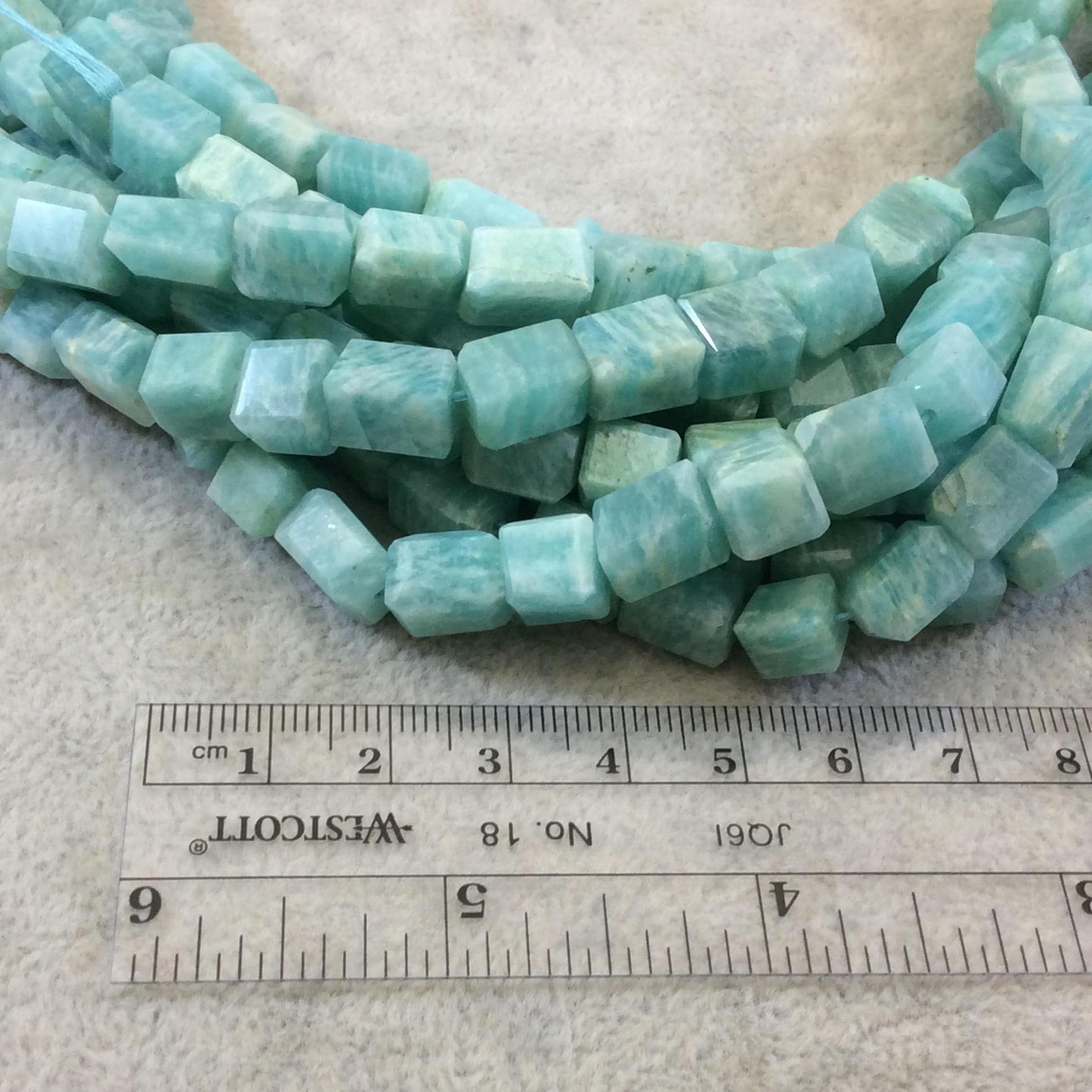 Image of a strand of Amazonite Beads laid out by a ruler to show that they are 10mm
