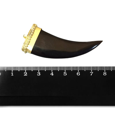 This is sizing photo with a ruler of a black horn pendant with a curved shape, used for jewelry making. The pendant has a glossy finish and a gold-plated bail at the top.